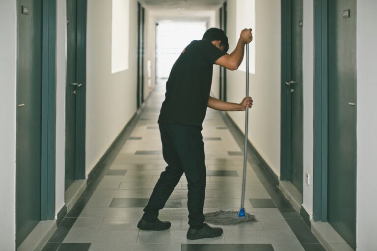 Employé de l'entreprise Vitre et Clair effectuant l'entretien professionnel du sol dans un couloir, service de nettoyage certifié à Genève disponible à la vente et livraison.